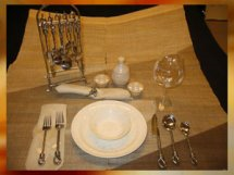 Set of Taos Twist handcrafted serving utensils beside holiday dishes and glassware.